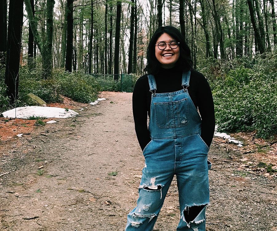 Solby Lim stands on a dirt trail in the woods