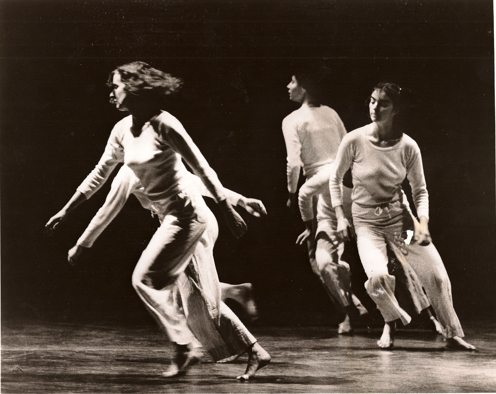 Trisha Brown dancing with three other women on stage