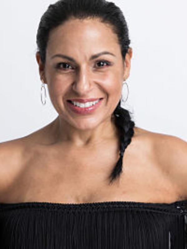 Female with Black fringe top, hair pulled back in ponytail braid on a white background. 